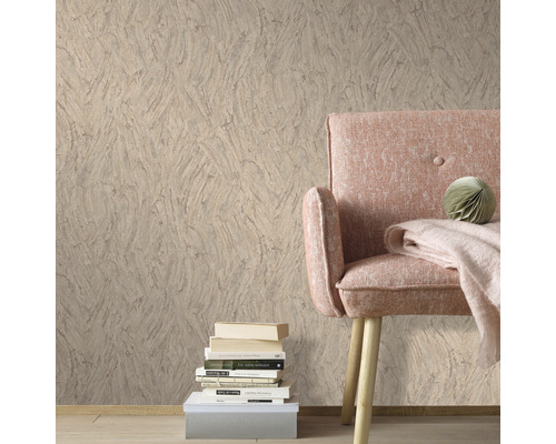 Woonkamer met patroonbehang, fauteuil en stapel boeken voor een gezellige sfeer