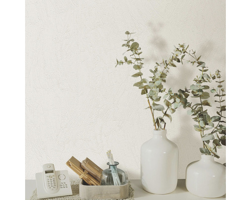 Close-up van een wit structuurbehang met telefoon en decoratieve vazen