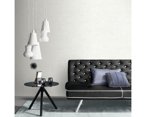 Interieur van een kamer met een zwarte bank met knopen, een zwarte tafel, decoraties en meerdere witte lampen