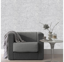 Woonkamer met grijs structuurbehang, fauteuil en tafel