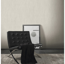 Woonkamer met patroonbehang, fauteuil en afbeelding