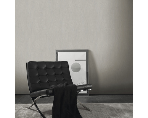 Lichte wand met structuur naast een fauteuil en een foto