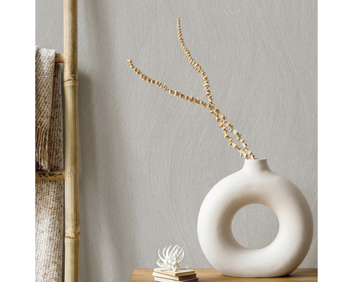 Lichte woonkamerinrichting met decoratieve vaas en bamboe rek tegen een gestructureerde muur