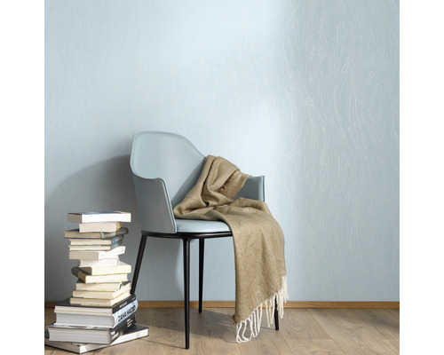 Scene met stoel, deken en stapel boeken tegen een muur