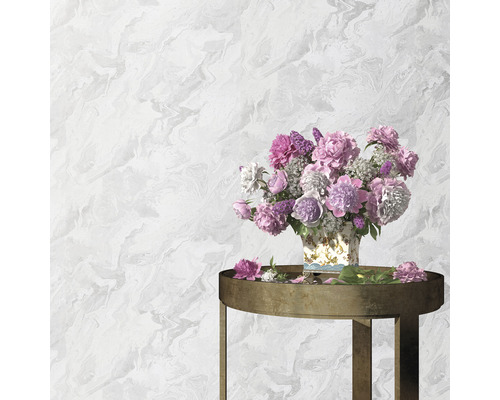 Wand met marmerbehang en tafel met bloemen