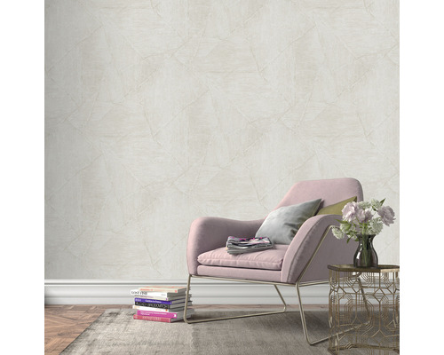 Scene met een muur met vliesbehang in steenlook, een fauteuil, een bijzettafel en decoraties voor een gezellige sfeer.