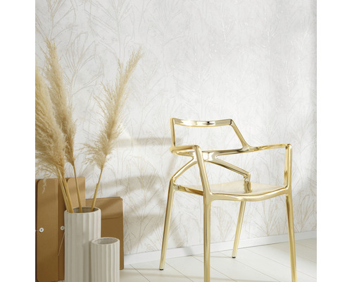 Decoratief behang met bladmotief, gecombineerd met gouden stoel en witte vazen op een lichte houten vloer.