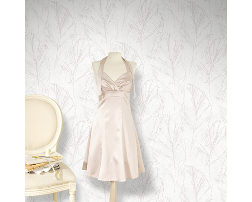 Behang met bladmotief, jurk op een paspop en stoel