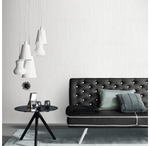 Woonkamer met bank, tafel en hanglampen voor een moderne inrichting.