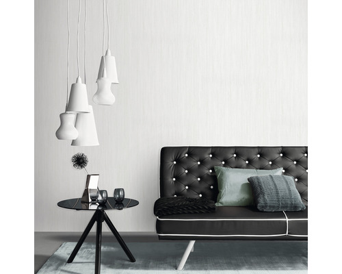 Woonkamer met bank, tafel en hanglampen voor een moderne inrichting.