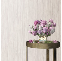 Boeket bloemen in een vaas op een tafel voor een gestructureerde wand