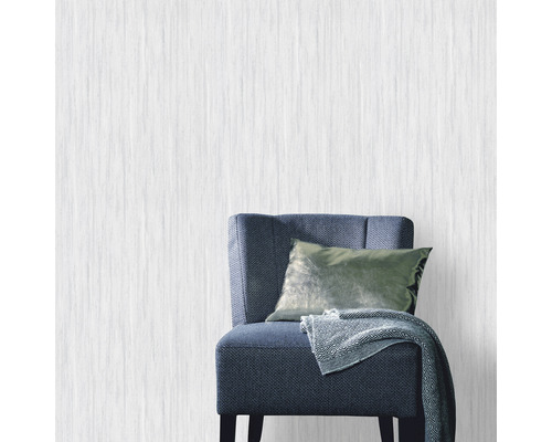 Licht vliesbehang in kamer met stoel, kussen en deken