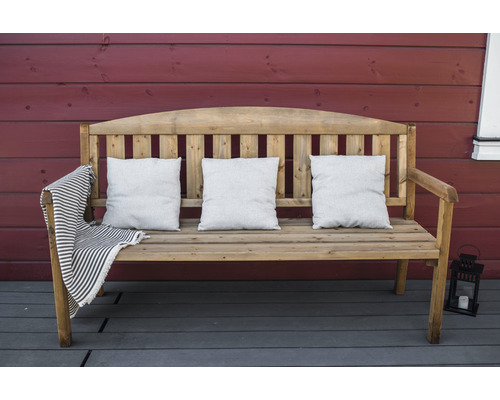 Houten bank met drie kussens en een gestreepte deken op een terras