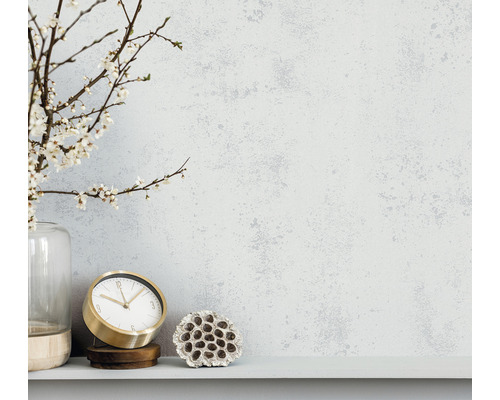 Decoratieve scène met bloeiende takken in vaas, gouden klok en gedroogde lotusbloem op een plank