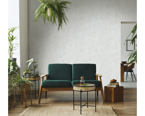 Woonkamer met groene bank, bijzettafels en gestructureerd wandbehang