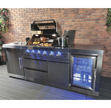 Roestvrijstalen buitenkeuken met barbecue, gootsteen en koelkast voor een bakstenen muur