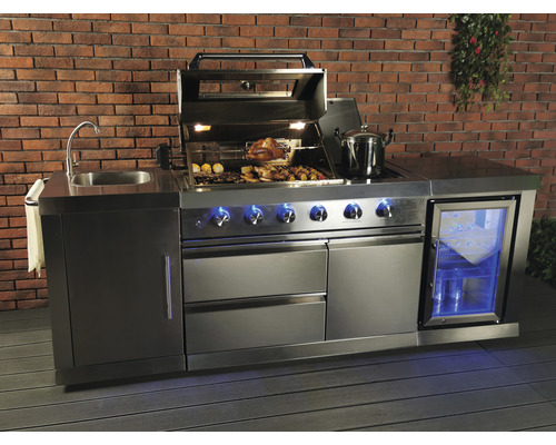 Roestvrijstalen buitenkeuken met spoelbak, barbecue, koelkast en opbergruimte voor een bakstenen muur