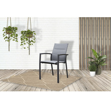 Tuinscène met een grijze tuinstoel op een vloerkleed met patroon