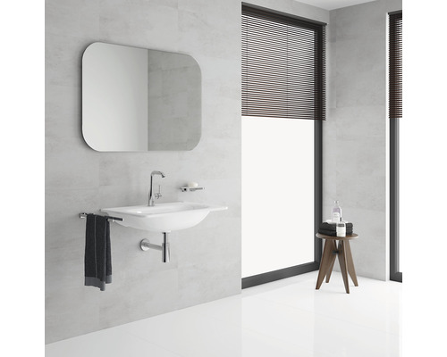 Lichte badkamer met wastafel, spiegel en raam met jaloezieën.