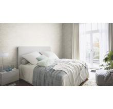 Lichte slaapkamer met bed, nachtkastje en gestructureerd behang