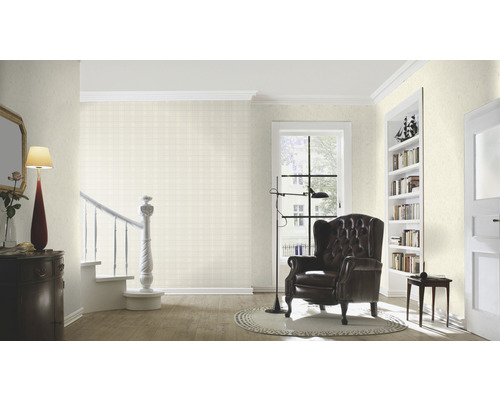 Woonkamer met fauteuil, staande lamp en trap met patroonbehang