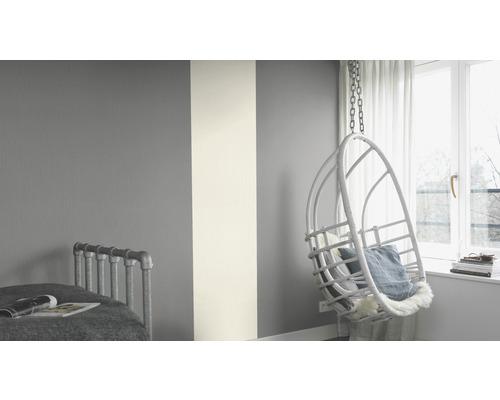 Lichte kamer met gestreepte behang, hangstoel en bed