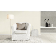Woonkamer scène met fauteuil, vloerlamp en decoratie