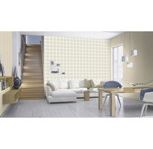 Woonkamer met trap, bank, eettafel, stoelen en behang met ruitpatroon