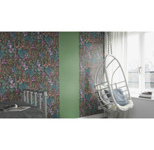 Gedecoreerde kamer met behang met bloemmotief, een schommelstoel en een bed.