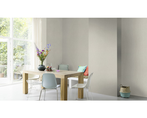 Lichte eetkamer met houten tafel, stoelen en patroonbehang