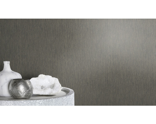 Close-up van een gestructureerd wandbehang naast decoratieve objecten op een tafel.