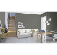 Woonkamer met grijs behang, trap, witte bank en houten tafel