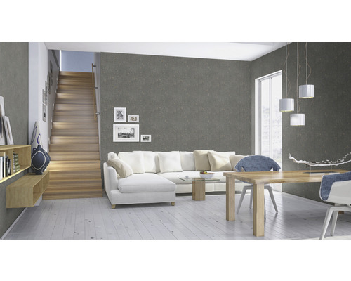 Woonkamer met grijs behang, trap, witte bank en houten tafel