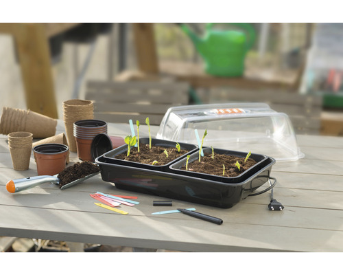 Kweekset met plantenbakken, kweekpotten en tuingereedschap op een tafel