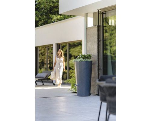 Regenton met beplanting en kraan in de tuin