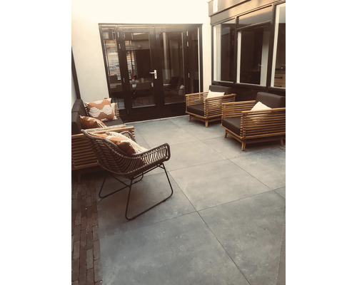 Terras met tuinmeubelen, fauteuils en stenen tegels