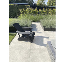 Tuin met tuinstoel, planten en vloertegels