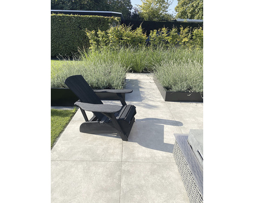 Tuin met tuinstoel, planten en vloertegels