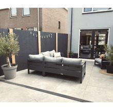 Moderne tuin met loungemeubels, privacyscherm en olijfboom in pot
