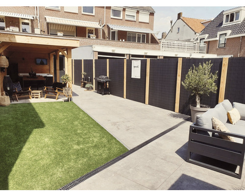Aangelegde tuin met barbecueplaats, kunstgras, tuinmeubelen en privacyscherm