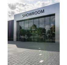 Entree van een showroom met glazen gevel en plantenbakken