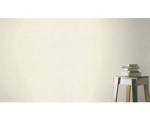 Close-up van een wandbekleding met een subtiel patroon naast een stapel boeken op een kruk