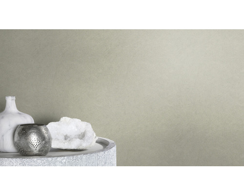 Close-up van een beige vliesbehang met fijne structuur