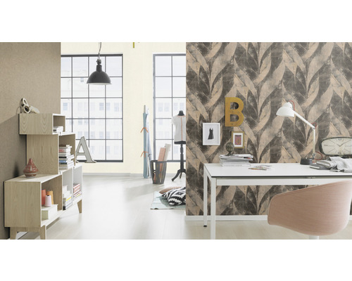 Een lichte kamer met meubels, bureau en een muur met bladmotief behang.