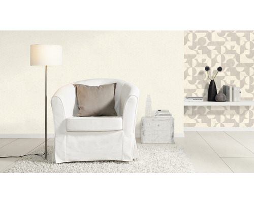 Woonkamer met fauteuil, vloerlamp en behang met patroon voor een lichte en vriendelijke sfeer