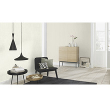 Woonkamer met hanglampen, fauteuil en commode