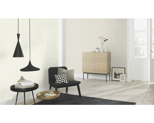 Woonkamer met hanglampen, fauteuil en commode