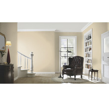 Lichte woonkamer met behang, fauteuil en trap