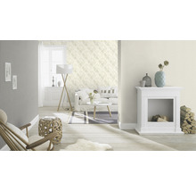 Woonkamer met bank, lamp, open haard en behang met motief