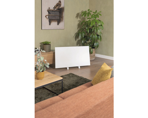 Woonkamer met verwarmingspaneel, bank, tafel en kamerplanten